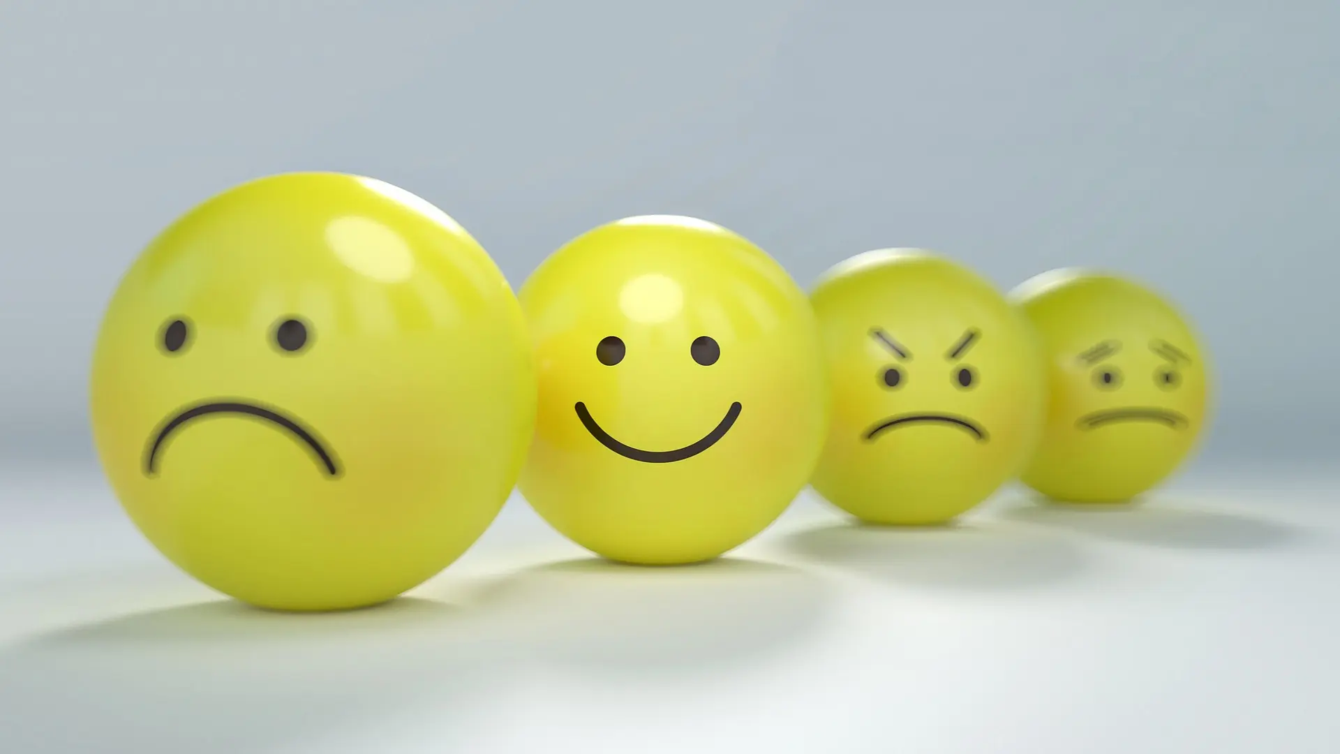 A set of emotions drawn on some colourful yellow balls